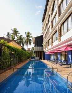 a swimming pool in front of a building at Rio Boutique in Candolim