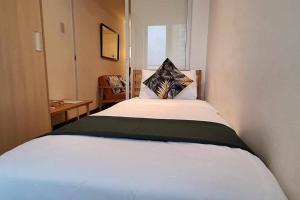 - une chambre dotée d'un lit blanc avec un oreiller dans l'établissement Azure 2BR Resort Living in the City with Wifi, à Manille