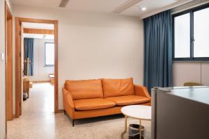 a living room with an orange couch and a table at Tingjian Musu Private Soup Design Homestay - South Gate of Wuzhen Xizha Scenic Area in Tongxiang