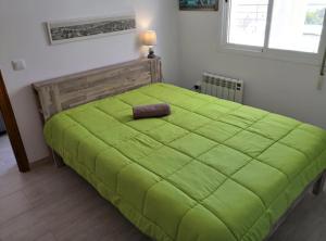 ein großes grünes Bett in einem Zimmer mit Fenster in der Unterkunft villa piscine privee et vue Magnifique sur la mer in Cumbre del Sol