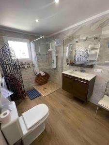 ein Bad mit einem WC, einer Dusche und einem Waschbecken in der Unterkunft villa piscine privee et vue Magnifique sur la mer in Cumbre del Sol
