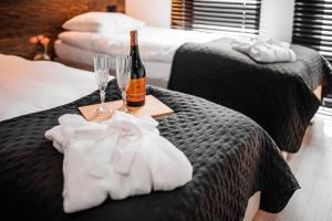 two beds with a bottle of champagne and two wine glasses at Plaża Resort in Morąg