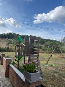 un parque infantil de madera con columpio y flores en B&B La Caruscia en Trivento