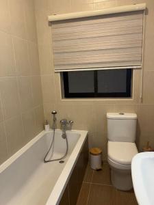een badkamer met een bad, een toilet en een raam bij Seafront apartment in St Julians in St Julian's