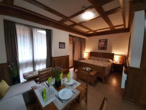 ein Hotelzimmer mit einem Bett, einem Tisch und Stühlen in der Unterkunft Private Studio Pirin Golf Hotel Bansko in Raslog