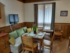 ein Wohnzimmer mit einem Sofa und einem Tisch in der Unterkunft Private Studio Pirin Golf Hotel Bansko in Raslog