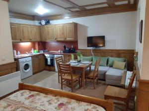 eine Küche und ein Wohnzimmer mit einem Tisch und einem Sofa in der Unterkunft Private Studio Pirin Golf Hotel Bansko in Raslog