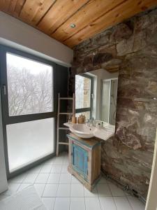 a bathroom with a sink and a stone wall at Hallgarter Zange in Oestrich-Winkel