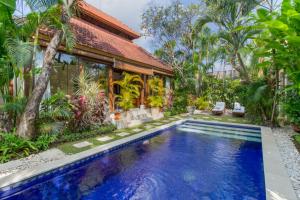 a villa with a swimming pool in front of a house at Villa Istana 1 in Seminyak
