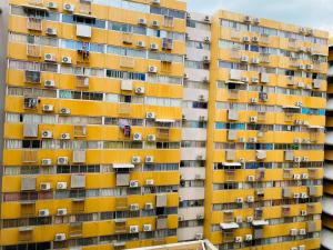 un edificio de apartamentos con ventanas y balcones amarillos en Condo popular T8 fl.9.2 en Thung Si Kan