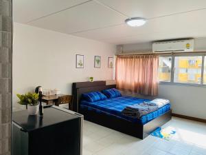 a bedroom with a bed and a desk in it at Condo popular T8 fl.9.2 in Thung Si Kan