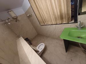 a bathroom with a green sink and a toilet at Hotel V inn Sindhi Camp in Jaipur +26 photos