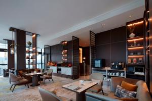 a living room with couches and tables and chairs at Momentus Hotel Alexandra in Singapore
