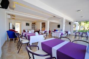 a restaurant with purple and white tables and chairs at Fuda Hotel in Datca