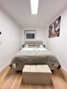 ein weißes Schlafzimmer mit einem großen Bett und einem Fenster in der Unterkunft Souterrainwohnung - Remseck am Neckar in Remseck-Pattonville