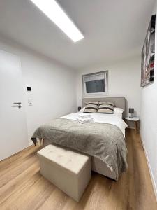 a white bedroom with a bed and a window at Souterrainwohnung - Remseck am Neckar in Remseck am Neckar