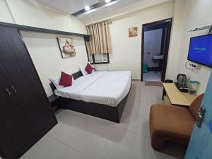 a bedroom with a bed and a tv in a room at Hotel V inn Sindhi Camp in Jaipur