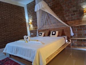 a bedroom with a bed with two stuffed animals on it at Bunga Maliq Bungalow Lombok in Tetebatu