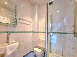 een badkamer met een douche, een toilet en een wastafel bij Reef Lodge in Newquay