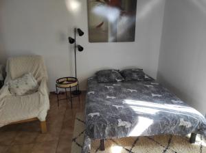 a bedroom with a bed and a chair at maison de campagne au calme in Chuelles