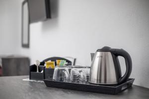 a tray with a tea kettle and glasses on a counter at Dorian's Domain Faliraki in Faliraki