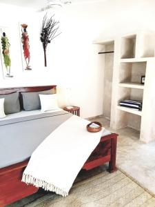 um quarto com uma cama com um cobertor branco em Michamvi Spirit Lodge em Michamvi