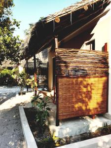 budynek z dachem krytym strzechą i drewnianą ścianą w obiekcie Michamvi Spirit Lodge w mieście Michamvi