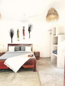 um quarto com uma cama grande e paredes brancas em Michamvi Spirit Lodge em Michamvi