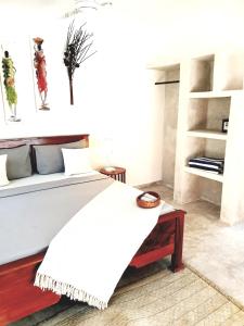 Michamvi Spirit Lodge في ميتشامفي: غرفة نوم بسرير وبطانية بيضاء