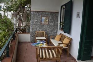 a patio with chairs and a table on a balcony at Casa Vacanze Bouganvillea in Cetara