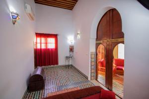 Habitación con cama y puerta roja en Riad Zitouna, en Fez