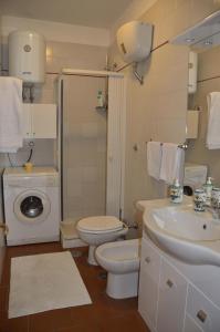 a bathroom with a toilet sink and a washing machine at Casa Vacanze Bouganvillea in Cetara