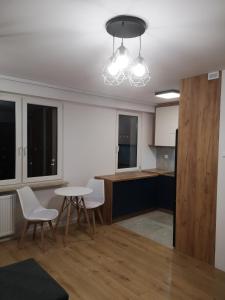 a kitchen with a table and chairs in a room at Małe mieszkanie in Łomża