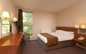 a hotel room with a bed and a desk at St James Hotel in Grimsby +25 photos