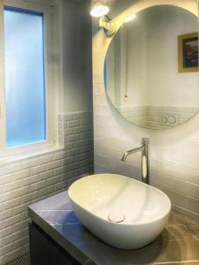 Casa del vicolo Fortunato في تشيفيتافيكيا: حمام مع حوض أبيض ومرآة