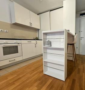 a kitchen with white cabinets and a stove top oven at MSS Spot in Zagreb