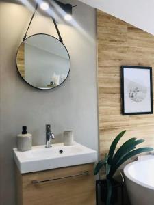 a bathroom with a white sink and a mirror at Qwadrat Apartament 15 in Bielsko-Biala city center in Bielsko-Biała