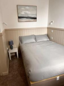 a bedroom with a bed and a side table at 73 George Street. Appartment 1 in Oban