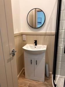 a bathroom with a white sink and a mirror at 73 George Street. Appartment 1 in Oban