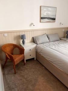 a bedroom with a bed and a chair and a nightstand at 73 George Street. Appartment 1 in Oban