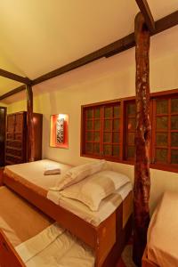un dormitorio con una cama y un árbol dentro en El Puerto Marina Beach Resort & Vacation Club, en Lingayen