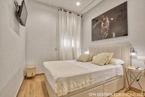 um quarto branco com uma cama e uma televisão em Literato centro de la ciudad em Múrcia
