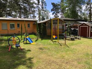 a yard with playground equipment and a house at Bungalow am Schwielochsee 2.0 in Schwielochsee