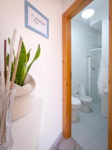 a bathroom with a toilet and a vase with a plant at A 50 scalini dal mare - Camera Doppia Privata in Maratea