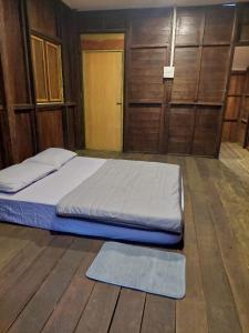 a bed in a room with a wooden floor at Jungle Zen Janda Baik Campsite in Kampung Janda Baik