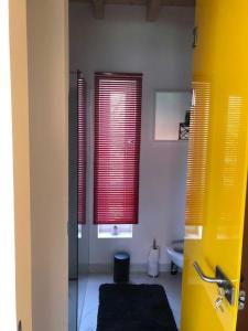 un bagno con specchio e finestre con persiane rosse di Art House - Révfülöp a Révfülöp