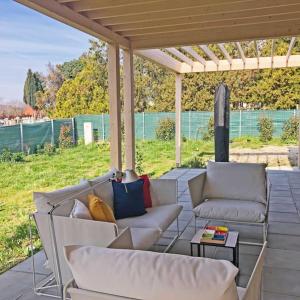 a patio with white couches and a pergola at Art House - Révfülöp in Révfülöp