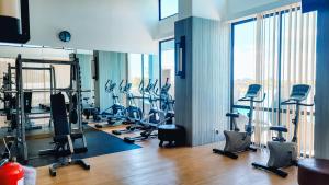 a gym with several treadmills and exercise bikes at Palam Mansion at Apartment One Residence in Batam Center