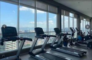 a gym with cardio machines in a room with windows at TR Residence MRT/Monorail/LRT/KLCC in Kuala Lumpur