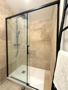 a shower with a glass door in a bathroom at Appartement - Loft Le Cosy in Hyères